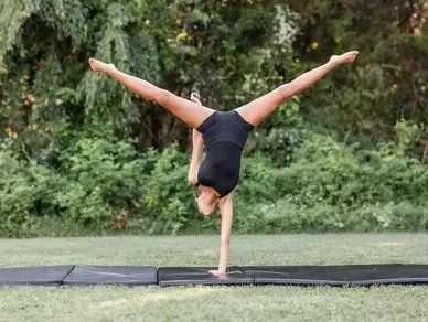 Acrobatics dancer performing handstand outdoors